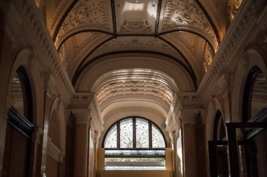Interior view of a building with ornate arched ceilings and intricate architectural details, showcasing a large decorative window. Such stunning destinations highlight remarkable natural light and timeless elegance.