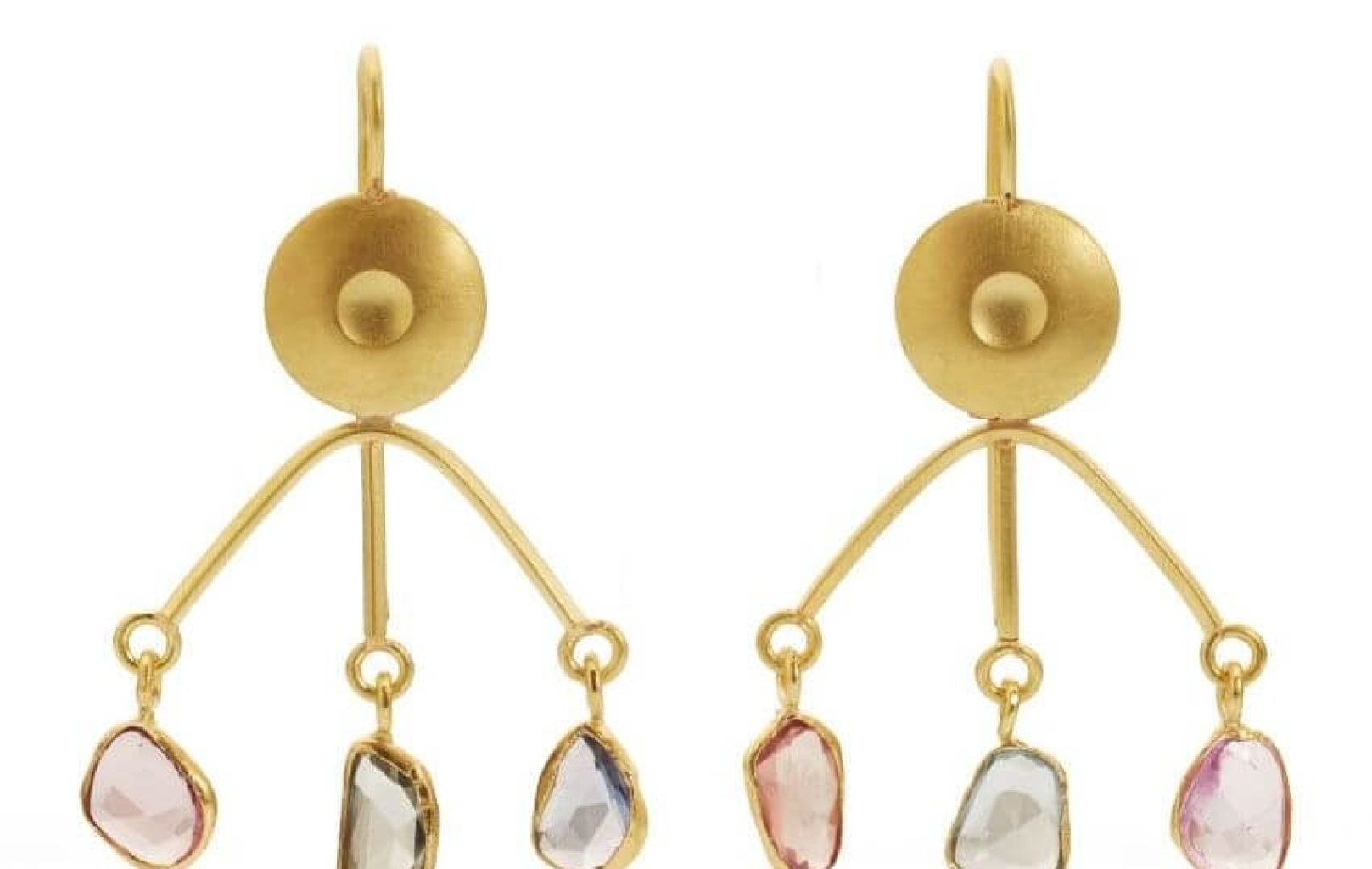 Gold earrings by Assumpta Bou feature a circular stud and three dangling, irregularly shaped gemstones in pink, clear, and blue hues on each earring.