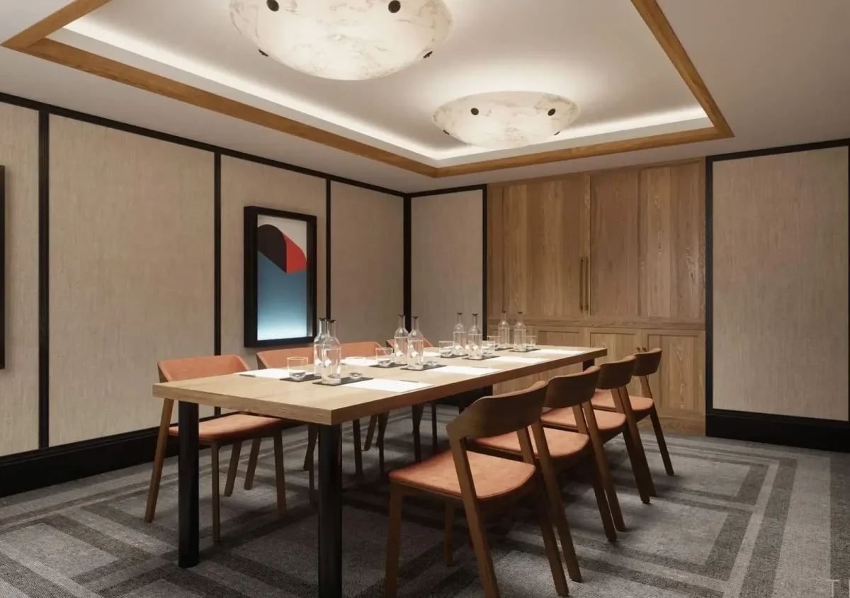 Ein moderner Konferenzraum mit einem Holztisch für sechs Personen, gepolsterten Stühlen, abstrakter Wandkunst und kreisförmigen Deckenleuchten.